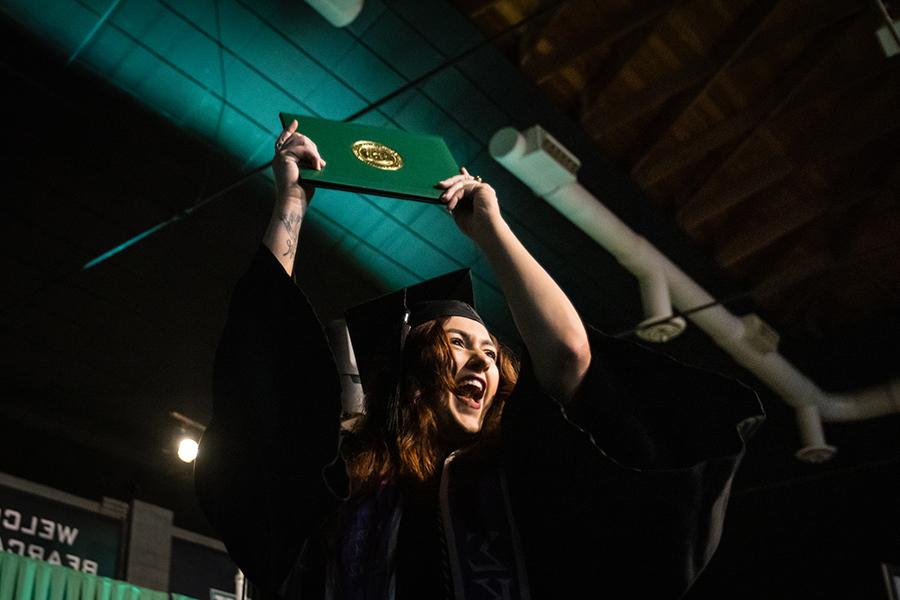 周六，<a href='http://its.lindamedia.net'>全国网赌正规平台</a>的一名毕业生在毕业典礼上展示她的毕业证书.